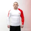 Athlète portant un rashguard BJJ à manches longues Stonebelt Heritage blanc et rouge, montrant une coupe compressée et une couverture complète des manches