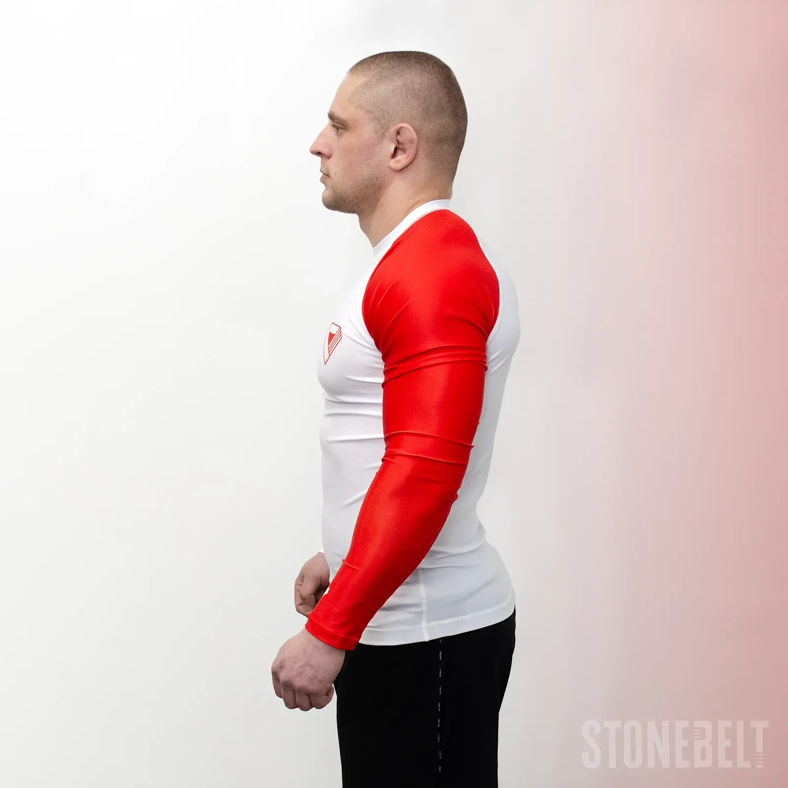 Left side profile of Stonebelt Heritage rashguard showing full red sleeve with maple leaf detail at wrist