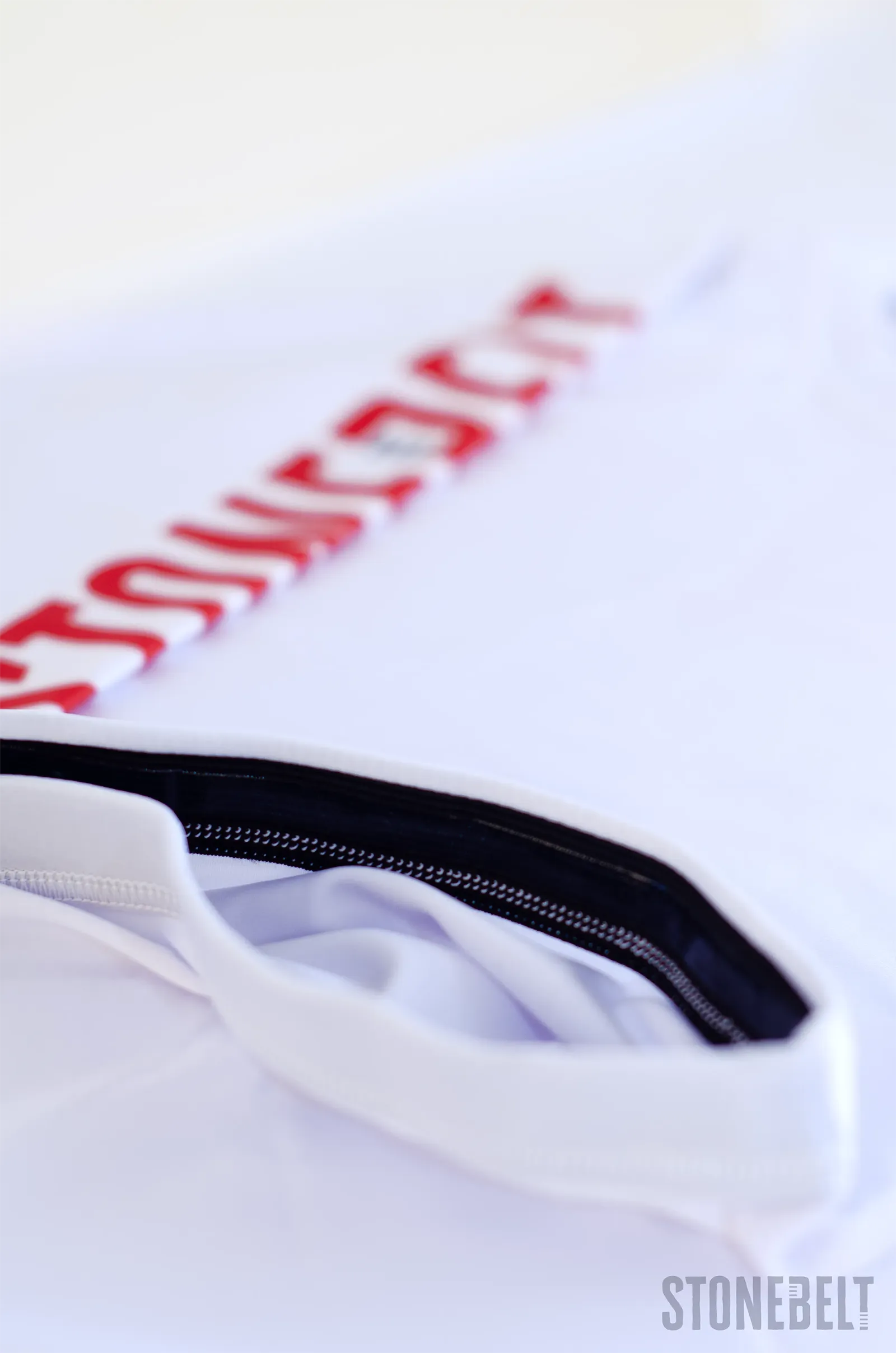 Close-up of Stonebelt Heritage rashguard silicone waist grip and Stonebelt branding along the hem