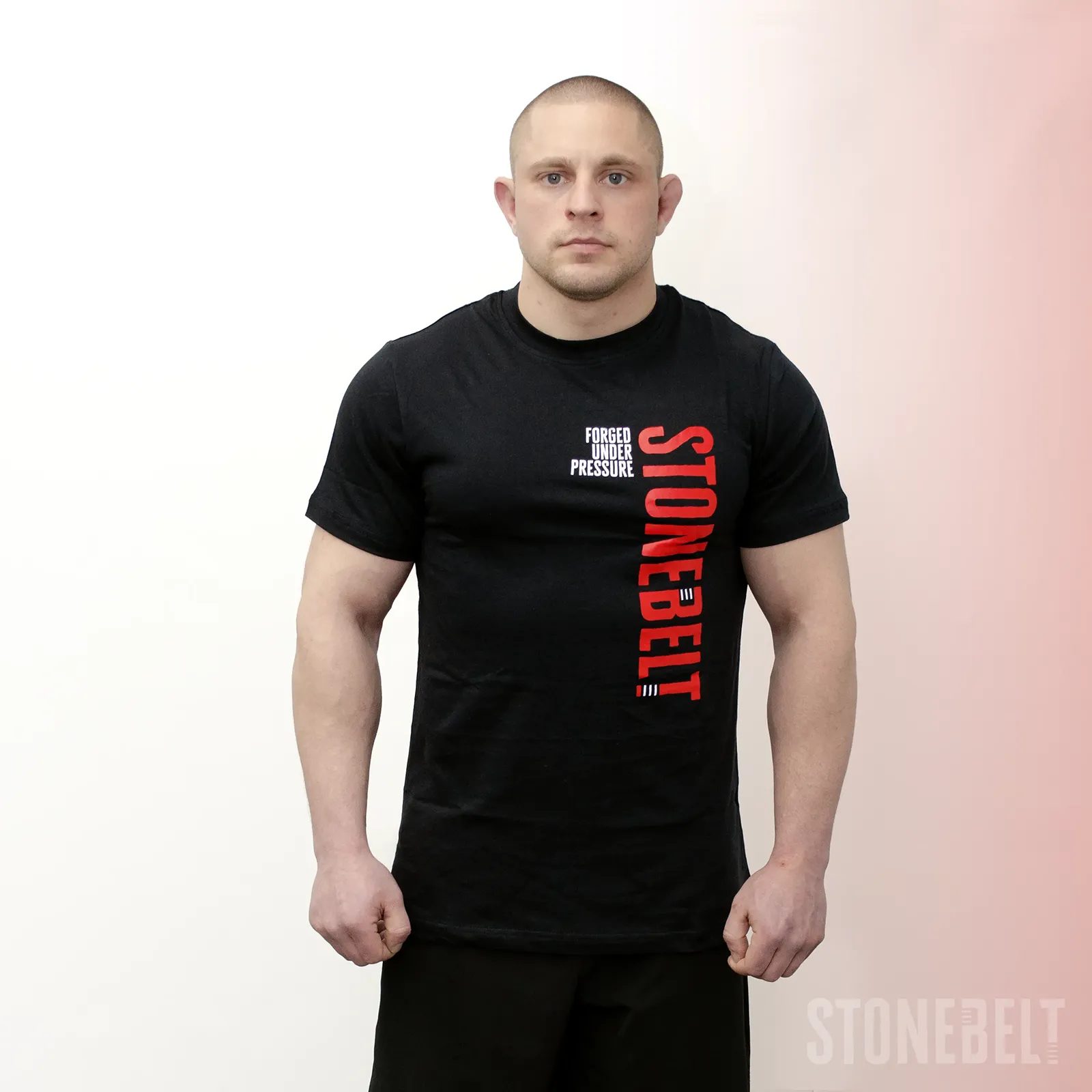 Athlete wearing Stonebelt Classic Logo Tee in black with red vertical Stonebelt branding and Forged Under Pressure text