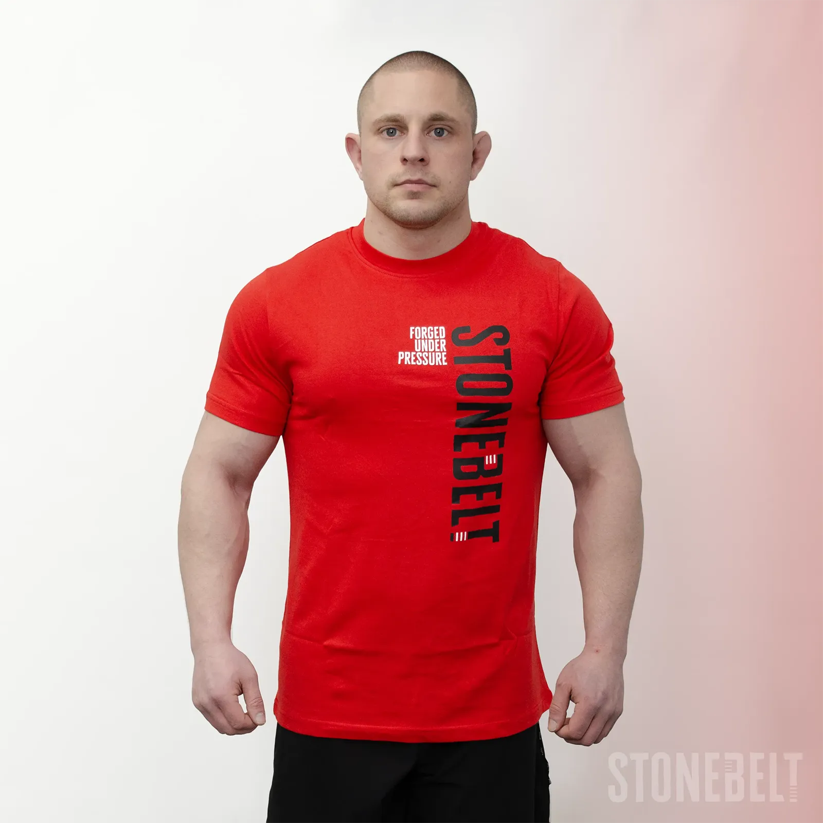Athlete wearing Stonebelt Classic Logo Tee in red with vertical Stonebelt branding and Forged Under Pressure text