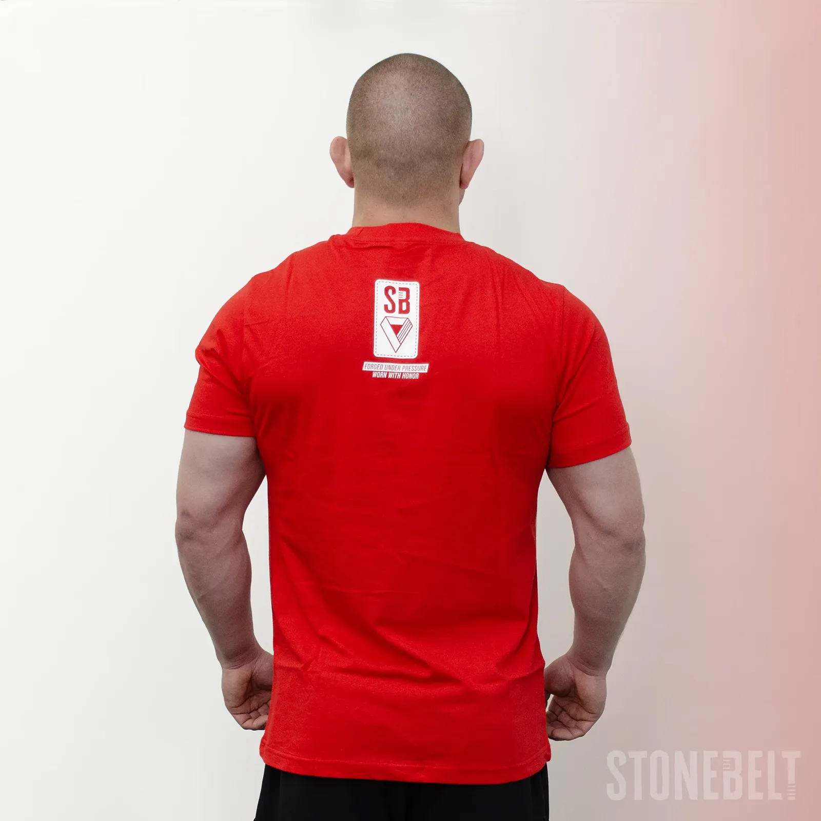 Back view of Stonebelt Classic Logo Tee in red showing SB logo badge with Forged Under Pressure Worn With Honor tagline