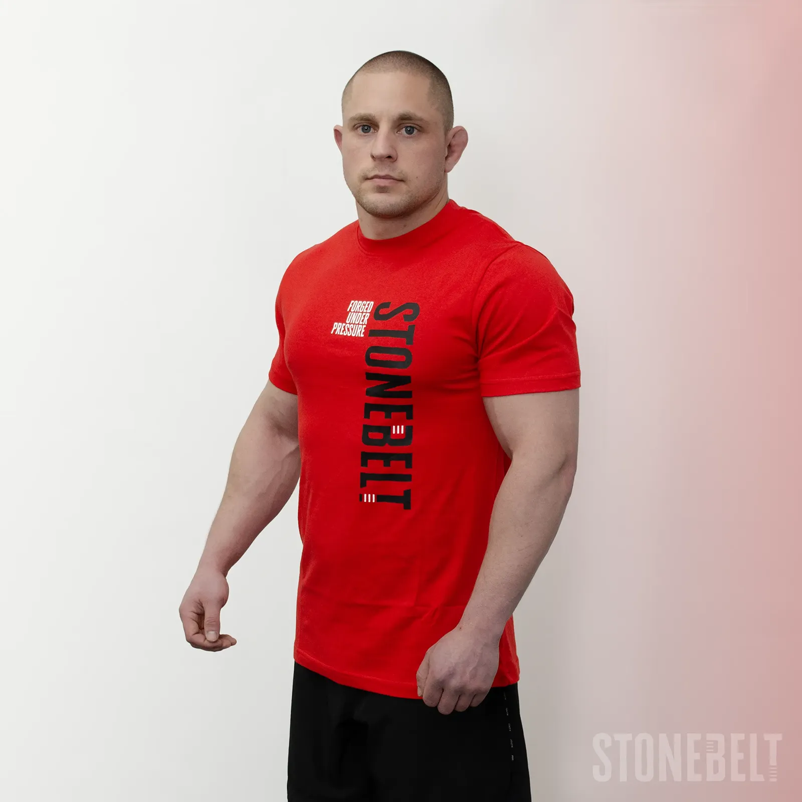 Three-quarter view of Stonebelt Classic Logo Tee in red showing vertical branding and athletic fit