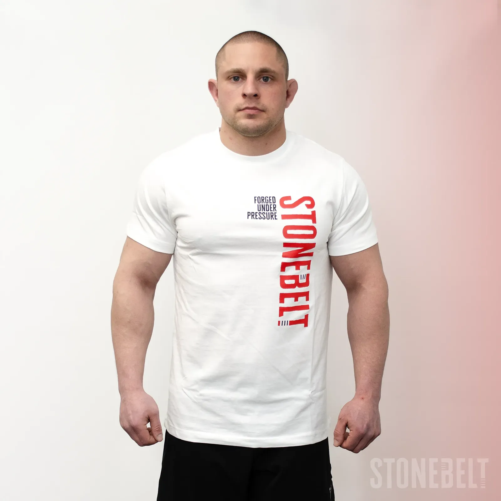 Athlete wearing Stonebelt Classic Logo Tee in white with red vertical Stonebelt branding and Forged Under Pressure text