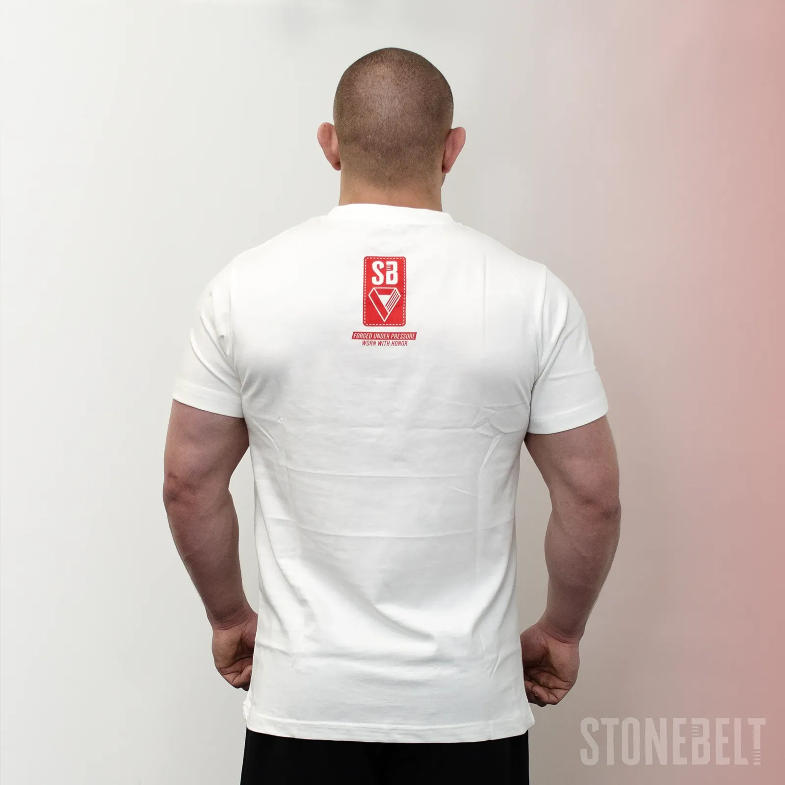 Back view of Stonebelt Classic Logo Tee in white showing red SB logo badge with Forged Under Pressure Worn With Honor tagline