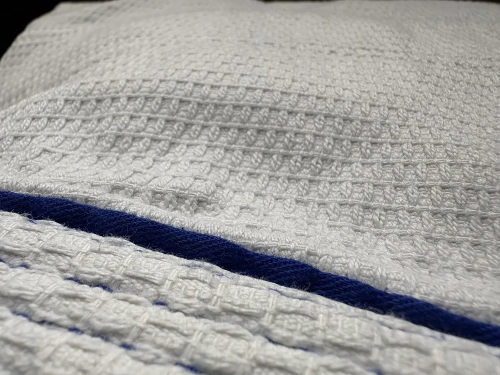 Closeup shot of a BJJ gi Jacket in Gold Weve pattern.