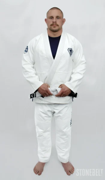 Stonebelt Heritage BJJ Gi in white, front view on model with white belt, showing pearl weave jacket and lapel