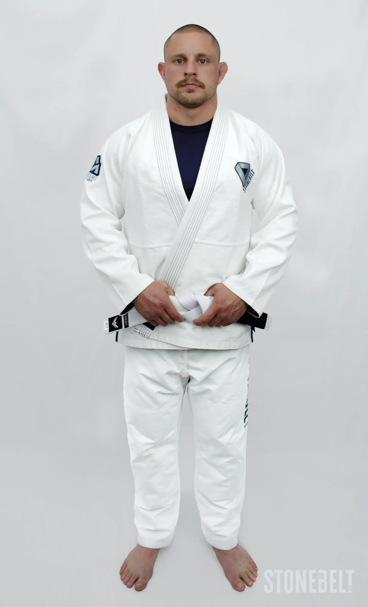 Stonebelt Heritage BJJ Gi in white, front view on model with white belt, showing pearl weave jacket and lapel