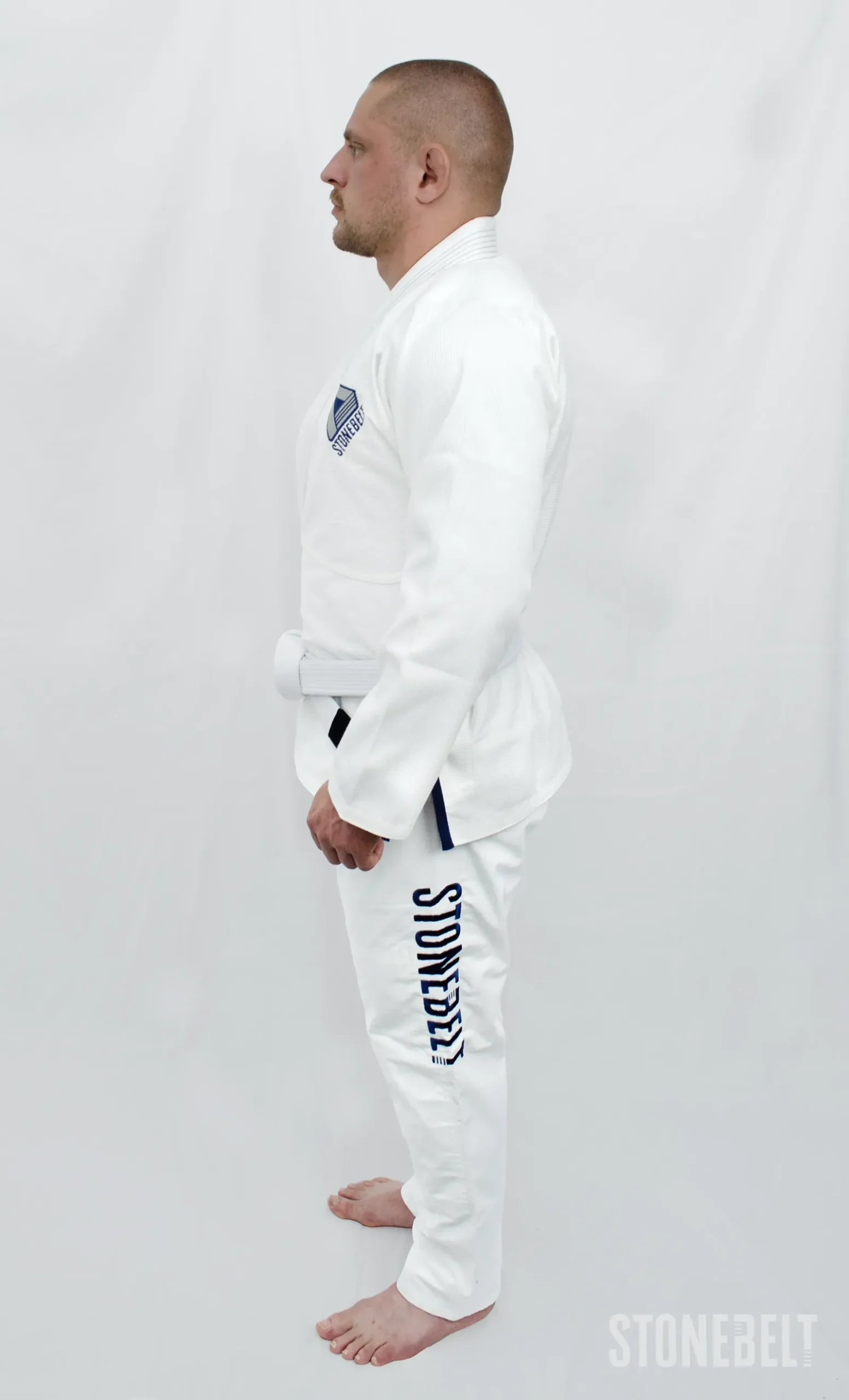 Stonebelt Heritage BJJ Gi in white, back view on model, with collar SB mark and Forged Under Pressure back patch