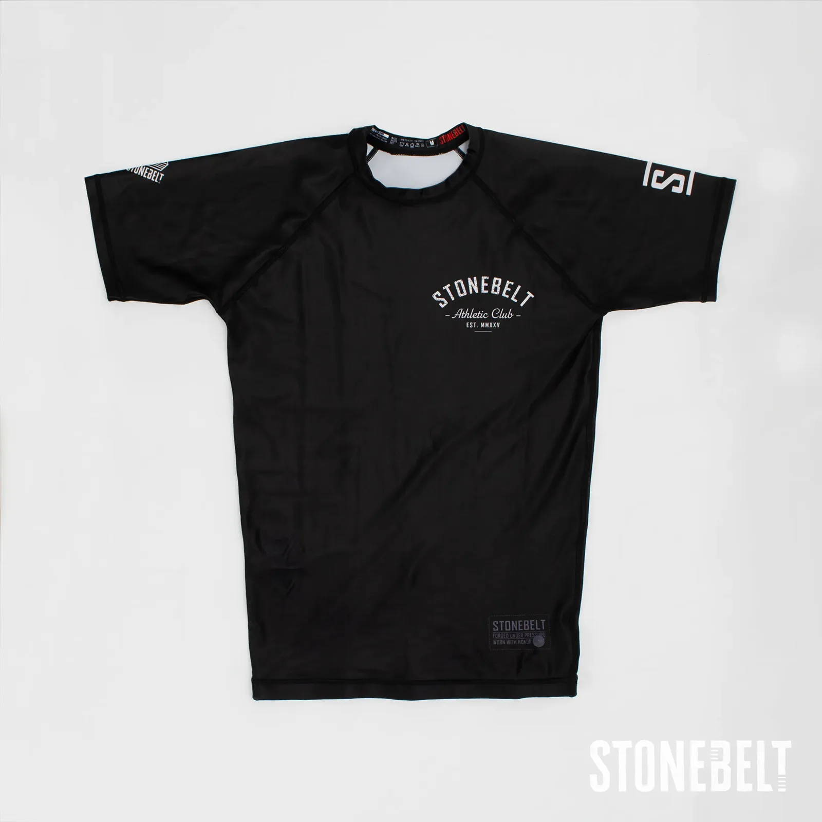 Stonebelt Athletic Club short sleeve BJJ rashguard in black, flat front view with chest and sleeve logos