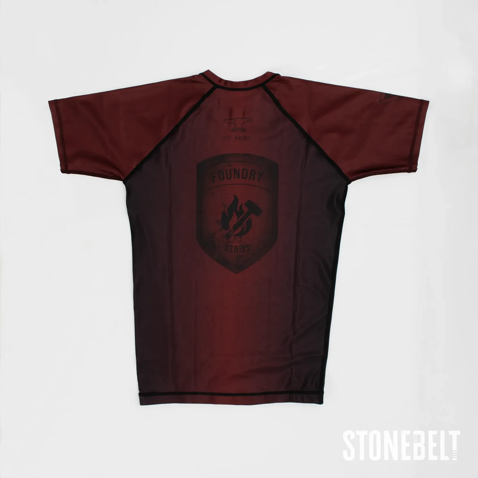 Stonebelt Foundry short sleeve BJJ rashguard in red and black, flat back view with Foundry Series shield graphic