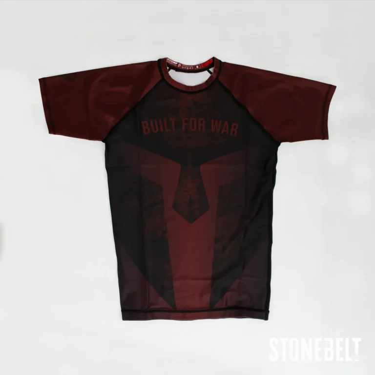 Stonebelt Foundry short sleeve BJJ rashguard in red and black, flat front view with Built for War spartan graphic