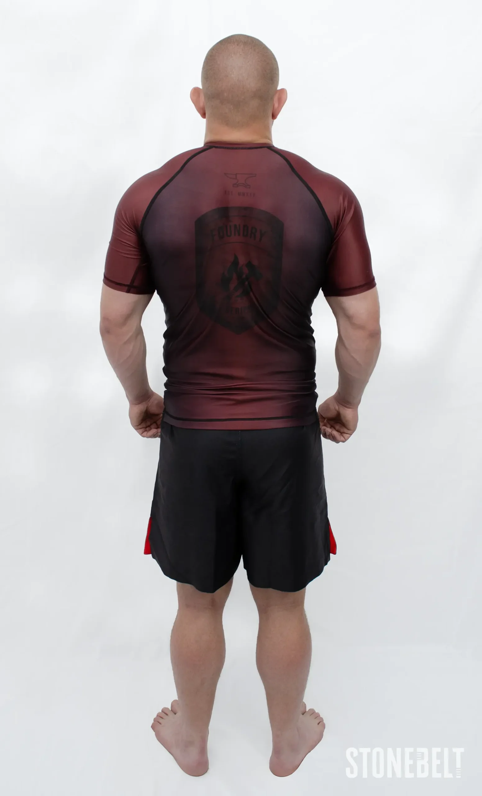 Model in Stonebelt Foundry red rashguard and black Heritage grappling shorts, back view