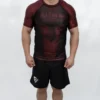Model in Stonebelt Foundry red rashguard with Built for War graphic and black Heritage grappling shorts, front view