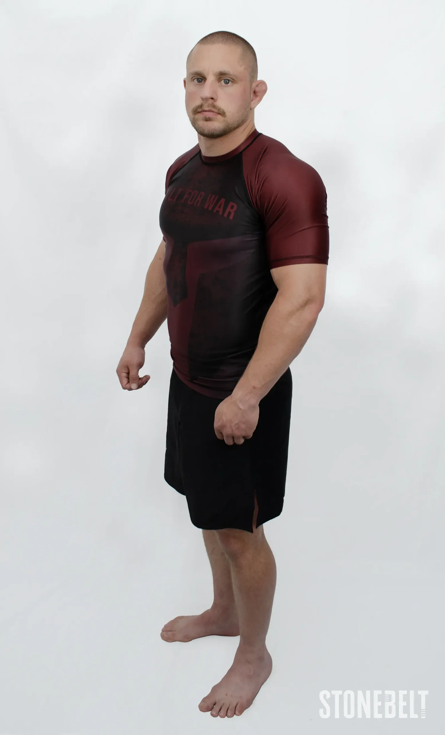 Model in Stonebelt Foundry red rashguard and black Heritage shorts, left side angled view
