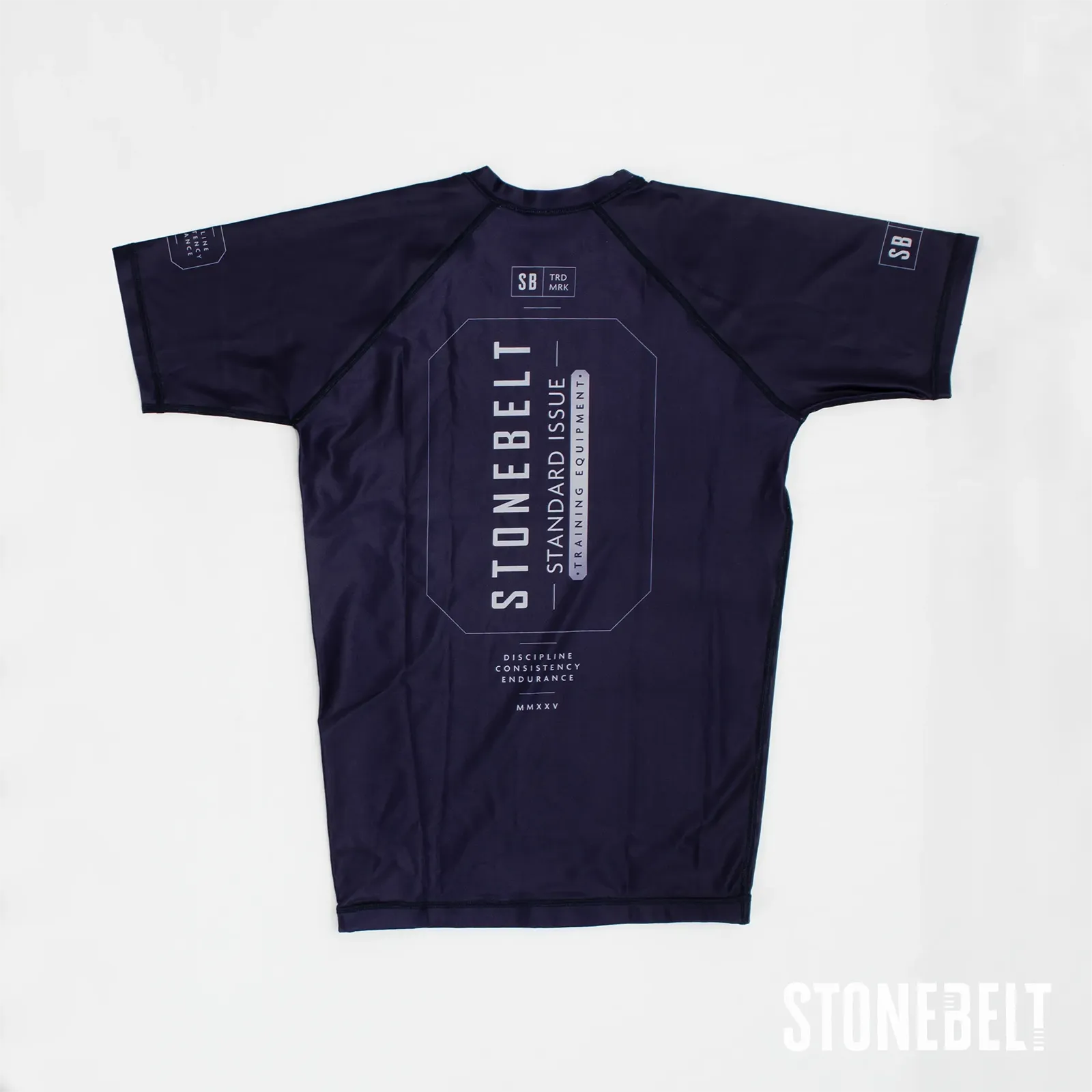 Stonebelt Standard Issue short sleeve BJJ rashguard in navy, flat back view with Discipline Consistency Endurance graphic