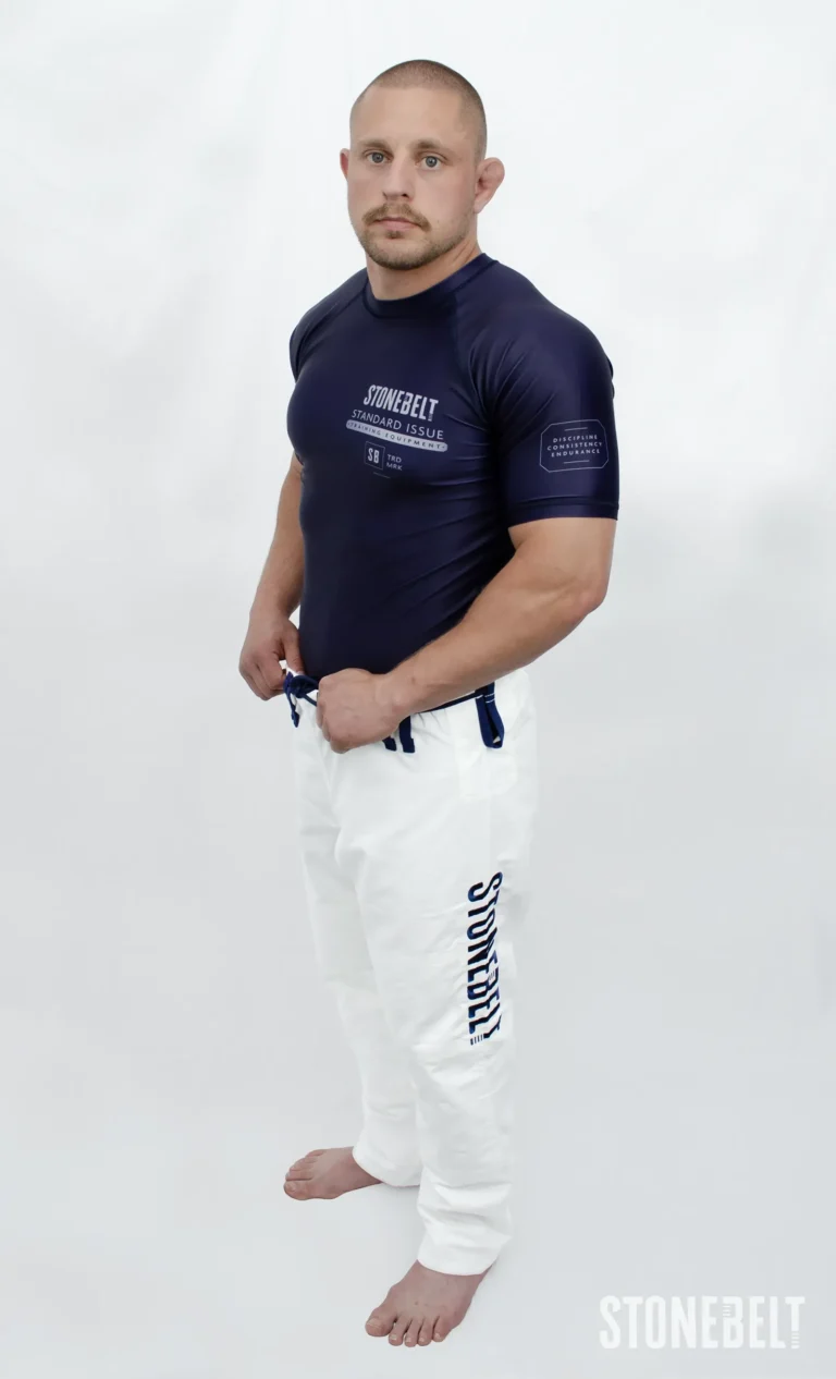 Model in Stonebelt Standard Issue navy rashguard and white Heritage gi pants, side view