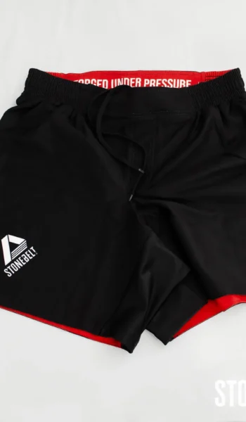 Stonebelt Heritage BJJ grappling shorts in black with red accents, front view, Forged Under Pressure waistband